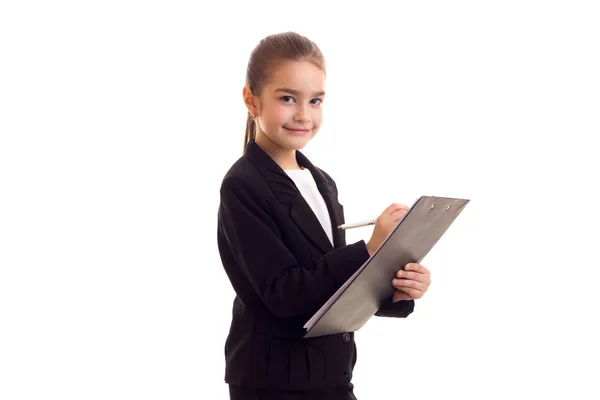Siyah ceketli kalem ve klasör tutan küçük kız — Stok fotoğraf