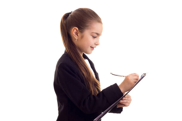 Little girl in black jacket holding pen and folder