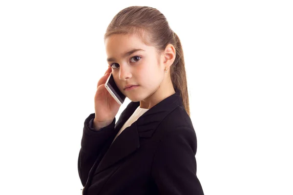 Siyah ceketli telefonda konuşurken küçük kız — Stok fotoğraf