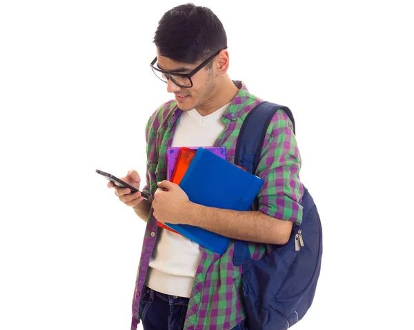 Молодой человек с рюкзаком, смартфоном и книгами — стоковое фото