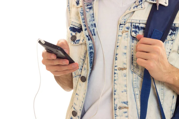 Młody człowiek z plecaka, smartphone i słuchawki — Zdjęcie stockowe