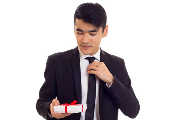 Молодой человек в костюме держит подарок — стоковое фото