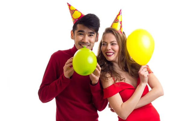 Jovem casal soprando balões — Fotografia de Stock
