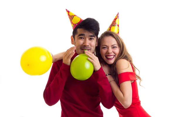 Jovem casal soprando balões — Fotografia de Stock