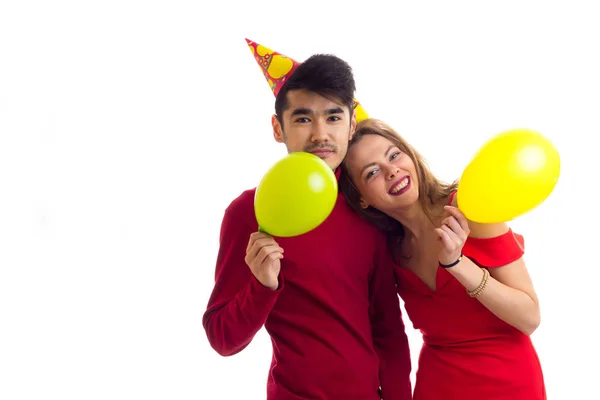 Joven pareja soplando globos — Foto de Stock