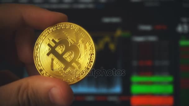 Νόμισμα Bitcoin στα χέρια του ανθρώπου απέναντι από το τερματικό συναλλαγών — Αρχείο Βίντεο