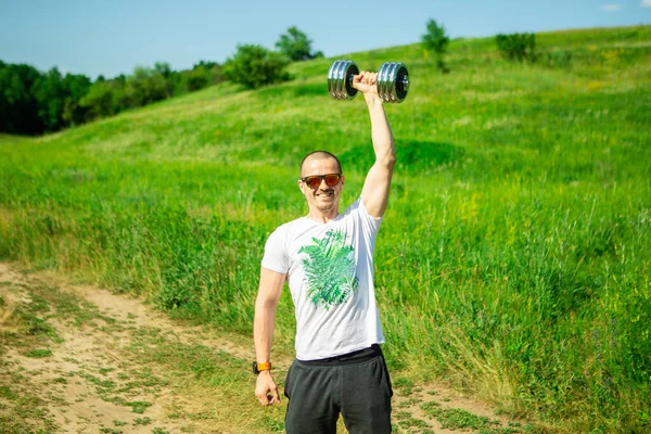 Man pushing dumbbell in hand over head — Stock Photo, Image