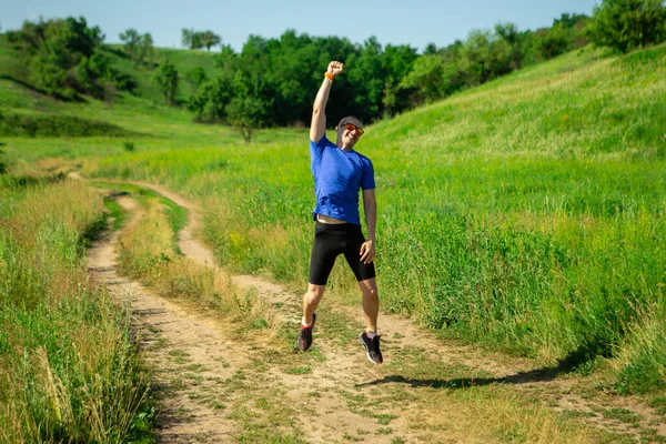 Muž běžec skákání a ukázat, že je vítěz závodu — Stock fotografie