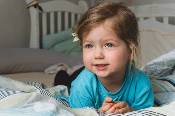 Porträt eines kleinen Mädchens, das auf dem Bett liegt — Stockfoto