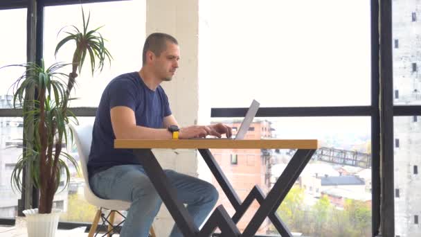 Hiperlapso de homem no trabalho com laptop no escritório moderno — Vídeo de Stock