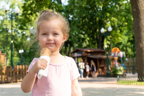 微笑的小女孩在公园里吃着冰淇淋 — 图库照片