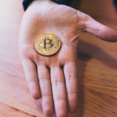 Şifreli para birimi Bitcoin 'in bozuk para sembolünü tutan adamın eli