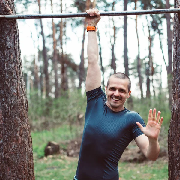 Sorrindo homem antes de treinar na floresta de pinheiros — Fotografia de Stock