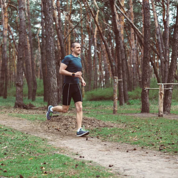Athlete run in the pine summer forest — Stock Photo, Image