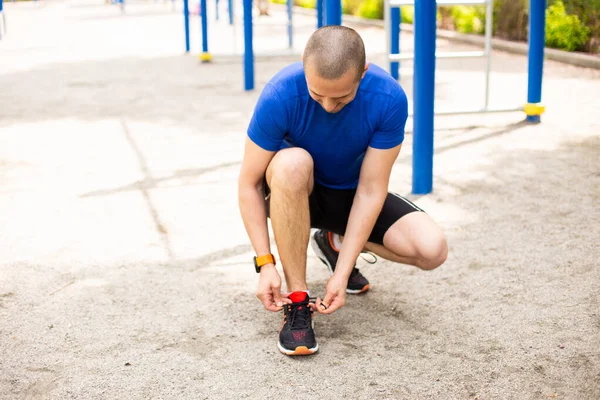 Mann bindet vor dem Training Schnürsenkel an Turnschuhe — Stockfoto