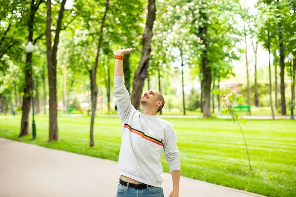 Un homme tenant quelque chose d'une main dans le parc — Photo