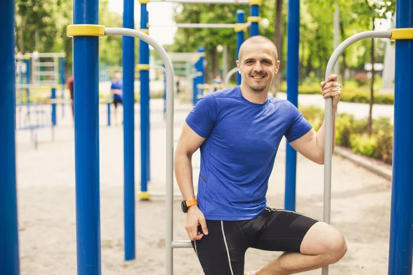 Fitness man looking in camera and smiling after workout
