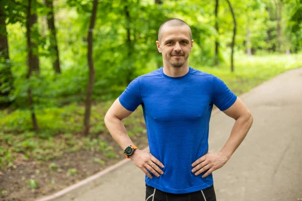 Sportowiec w niebieskim t-shirt patrząc w aparacie — Zdjęcie stockowe