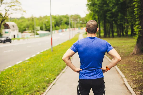 Uomo corridore prima di iniziare a correre guardando su strada — Foto Stock