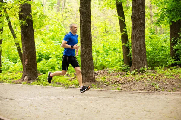 O corredor corre na floresta ou no parque. Treinamento duro — Fotografia de Stock