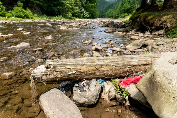 Plastikowe torby i butelki w górskiej rzece — Zdjęcie stockowe