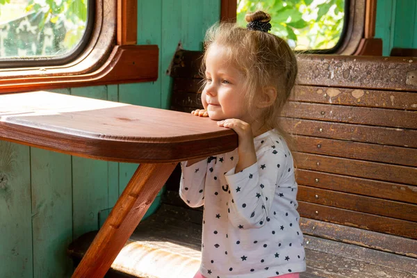 小さな女の子夢で座っている古いスタイルのレトロな電車 — ストック写真