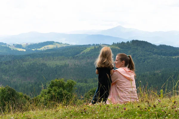 Женщина и девочка веселятся с видом на горы позади — стоковое фото