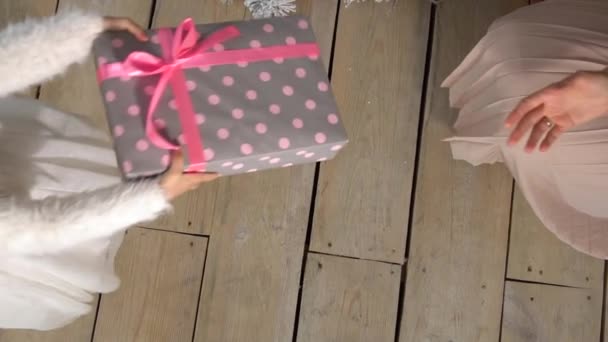 Το κοριτσάκι δίνει ένα κουτί δώρου στη γυναίκα τα Χριστούγεννα. — Αρχείο Βίντεο