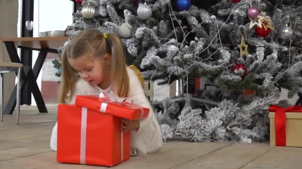 Criança feliz menina abrir caixa de presente e tira decorações de Natal — Vídeo de Stock
