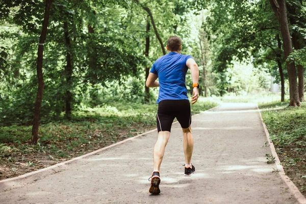 El hombre está corriendo en el parque urbano o bosque —  Fotos de Stock