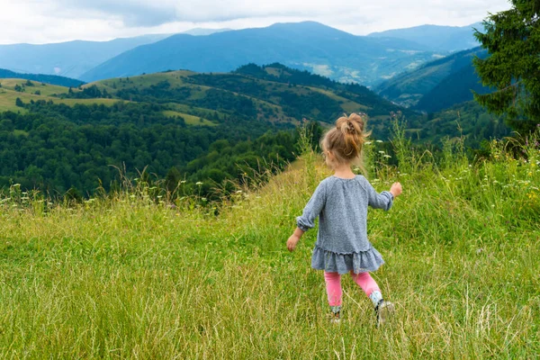 Menina de pé para trás para a câmera com vista incrível montanha — Fotografia de Stock