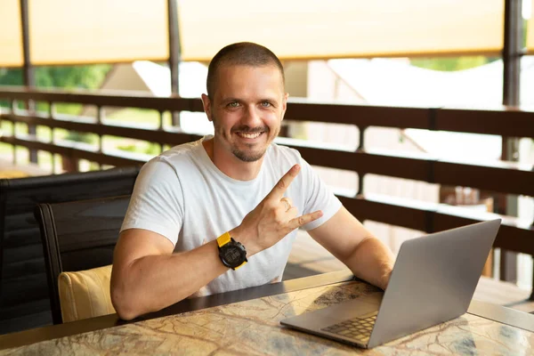 Man visar gest Rock på sitter vid skrivbordet med bärbar dator — Stockfoto