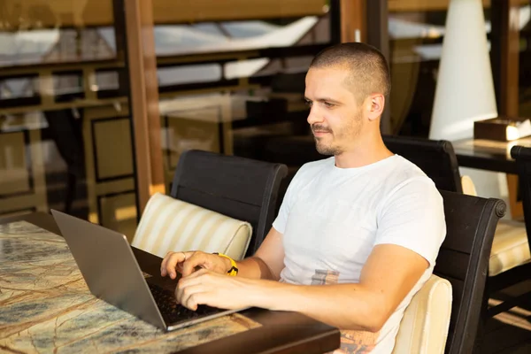 Mann schaut in Laptop und arbeitet online im Café — Stockfoto