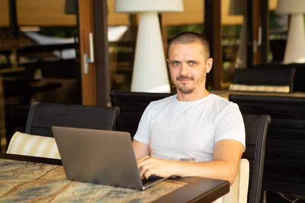 Man met laptop op zoek in de camera tijdens het zitten in cafe — Stockfoto