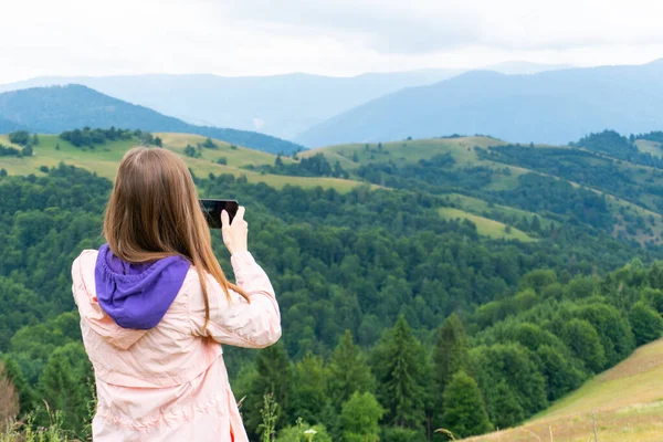 Mulher fazendo fotos de montanhas usando smartphone — Fotografia de Stock