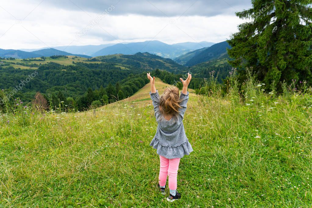 Happy little girl enjoy summer in the mountains