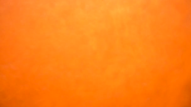 Orange bakgrund med rörliga glitter under vattnet — Stockvideo