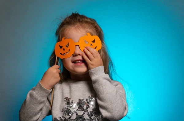 Helloween meisje kind met oranje bril van papier met pompkingen — Stockfoto