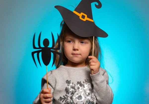 Klein meisje heks voor halloween kijken naar papier spin — Stockfoto