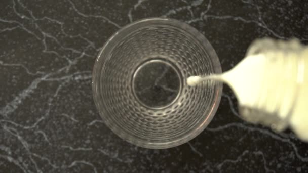 유리에 신선 한 우유를 부어 넣는 모습 이 위에서 내려다 보인다 — 비디오