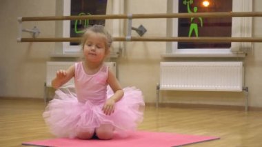 Koreografi sınıfında bale egzersizi yapan küçük bir kız.