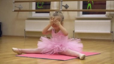 Pembe elbiseli küçük balerin koreografi çalışması yapıyor.