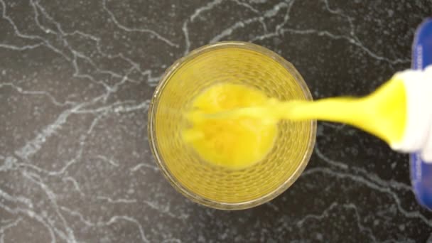 Orange juice poured in the glass from top view — Stockvideo