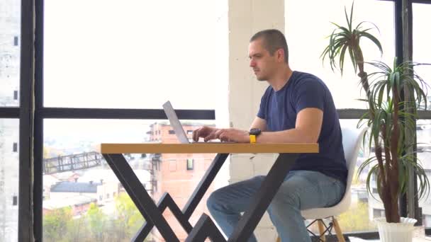 Man werkt op laptop in kantoor of coworking — Stockvideo