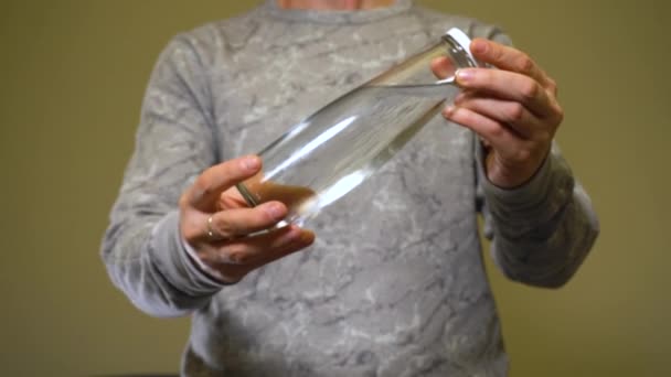 Man met glazen fles met helder zoet water. — Stockvideo