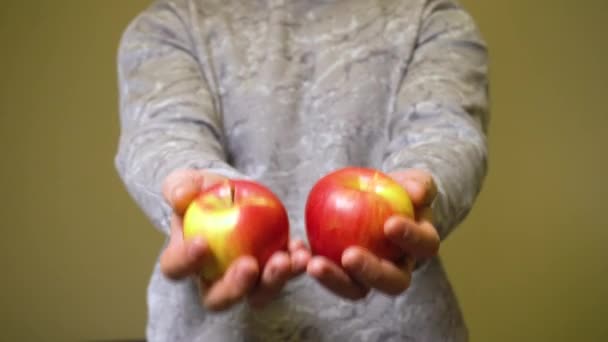 Uomo che tiene in mano due mele rosse — Video Stock