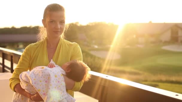 Sada videí ženy ve žluté blůze dandling její malé dítě v růžové přikrývce — Stock video