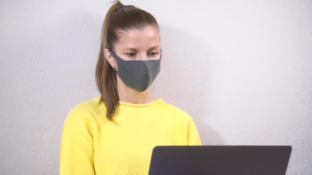 Vrouw freelancer in masker werken vanuit huis — Stockvideo