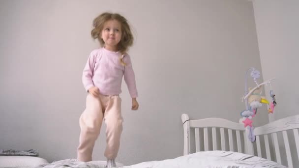 Komik ve mutlu kız yatakta zıplıyor — Stok video