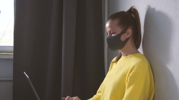 Kobieta w masce ochronnej pracuje w domu — Wideo stockowe